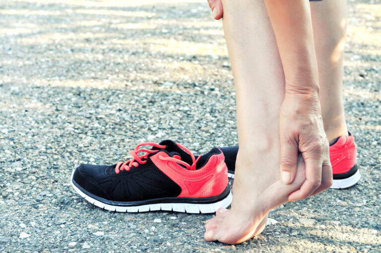 A woman suffering with heel pain from plantar fasciitis.