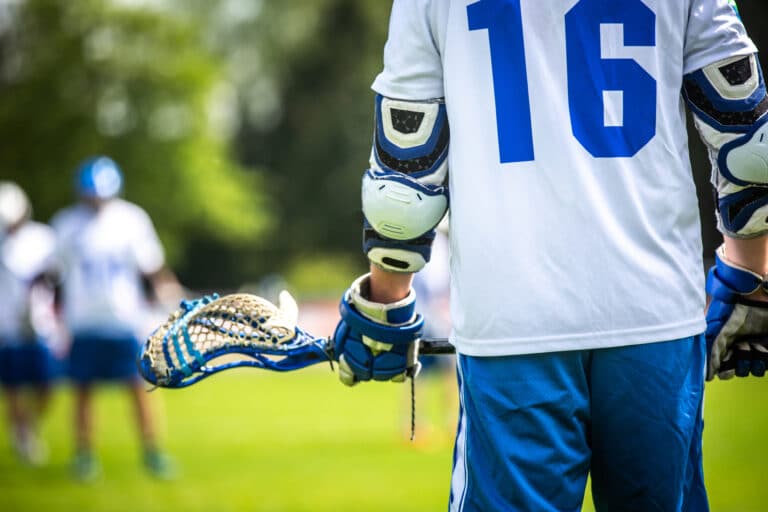 Lacrosse match, players, gear on the field, american sports themed photograph.